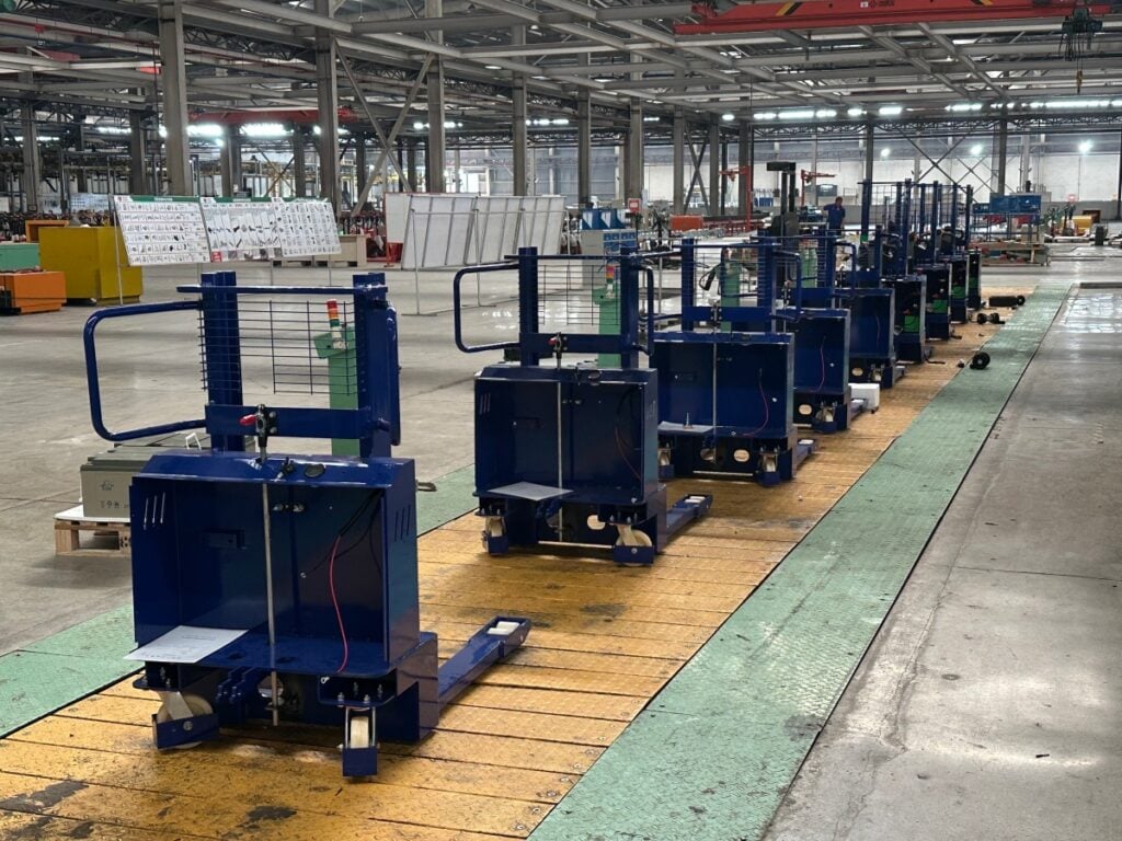The rigorous assembly process of our high-demand CDD1000-M700 fully electric paper roll lifter on the SINOLIFT factory floor.